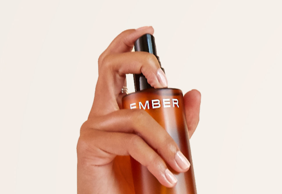 A hand gets ready to spritz a bottle of Ember hydrosol.